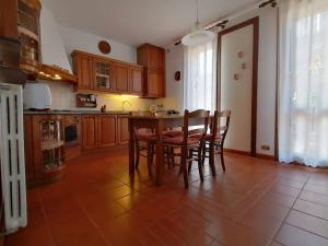 Villa Giuliana في فيغونزا: مطبخ مع طاولة وكراسي في غرفة