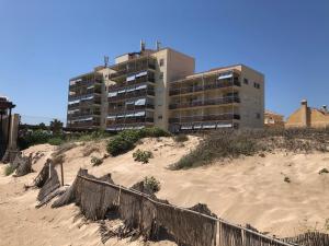 a building sitting on top of a sandy beach at Apartamento de playa Valmar - Beachfront exclusive residential in El Perellonet