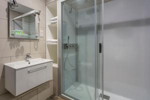 a bathroom with a glass shower and a sink at Roydon Marina Village Hotel in Roydon