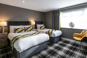 a hotel room with two beds and a window at Roydon Marina Village Hotel in Roydon