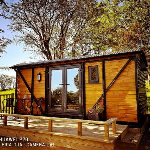 a wooden cabin with a large window on a deck at pen-rhos luxury glamping "The Hare Hut" in Llandrindod Wells