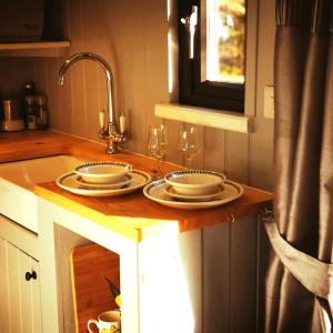 a kitchen counter with two plates and a sink at pen-rhos luxury glamping "The Hare Hut" in Llandrindod Wells