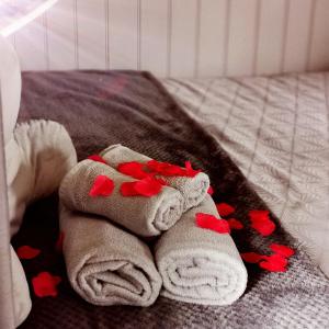 a folded towel with red hearts on a bed at pen-rhos luxury glamping "The Hare Hut" in Llandrindod Wells