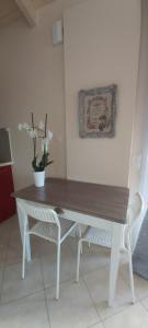 einen Holztisch mit zwei Stühlen und eine Vase mit Blumen in der Unterkunft Le Grand Bleu in Sitia