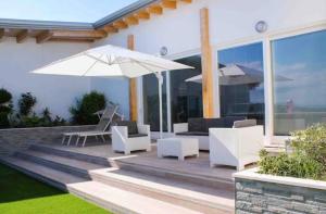 a patio with white furniture and an umbrella at TheVilla holiday in Silvi Marina