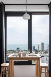 a table and chairs in front of a large window at Muji Studio 1 - Seaview at 218 Tropicana Near Komtar Food Heaven with Netflix & TV Box in George Town