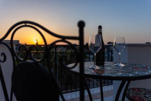 a table with two glasses and a bottle of wine at La Casetta sul Mare in Isola delle Femmine
