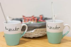 two coffee mugs with writing on them on a table at La Casetta sul Mare in Isola delle Femmine