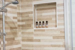 a bathroom with a shower with four bottles ofodorizers at La Casetta sul Mare in Isola delle Femmine
