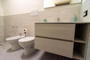 a bathroom with a toilet and a sink at La Casetta sul Mare in Isola delle Femmine