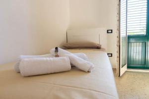 a bedroom with a bed with two towels on it at La Casetta sul Mare in Isola delle Femmine