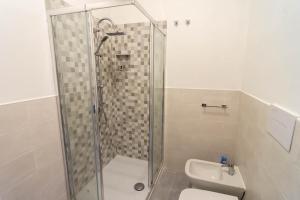 a bathroom with a shower and a toilet and a sink at La Casetta sul Mare in Isola delle Femmine
