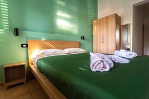 a green bedroom with two beds with towels on them at La Casetta sul Mare in Isola delle Femmine