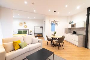 a living room with a white couch and a table at Chinitas Urban Aparments in Málaga