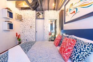 1 dormitorio con 1 cama con almohadas rojas y azules en Parrot Cottage at Viking Hill - Love Beach, en Nassau