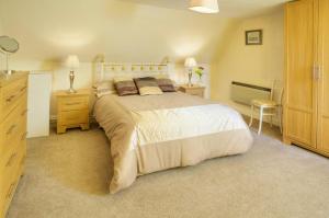 a bedroom with a large bed and two night stands at Willowherb and Foxglove Cottages Hawick in Hawick