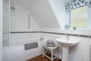 a white bathroom with a sink and a bath tub at Willowherb and Foxglove Cottages Hawick in Hawick