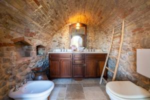 Baño de piedra con lavabo y aseo en Borgo Case Lucidi relax, en Torano Nuovo