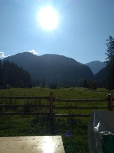 a fence in a field with mountains in the background at Gasthof Rettenbachalm in Bad Ischl