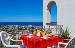 un tavolo con un piatto di cibo in cima a un balcone di Parco Residence La Rosa a Ischia