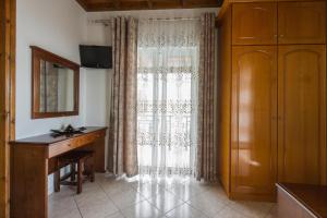 a room with a window with a desk and a dresser at MAKIS STUDIOS in Roda