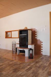 a living room with a table and a tv on a wall at Landhaus "Zum Frosch" in Kalbsrieth