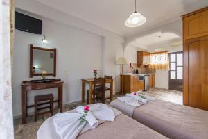 a bedroom with two beds with towels on them at MAKIS STUDIOS in Roda