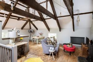 salon z drewnianymi podłogami i odsłoniętymi belkami stropowymi w obiekcie The Hideaway at Tregoose Old Mill w Newquay