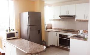 a kitchen with a stainless steel refrigerator and white cabinets at Smart Home with ocean view top floor in Tonsupa