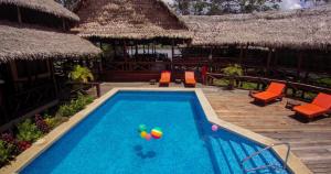 una piscina con sillas y pelotas en un complejo en Heliconia Amazon River Lodge, en Francisco de Orellana