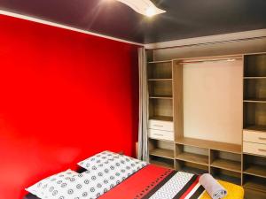 um quarto vermelho com uma cama e uma parede vermelha em La Madeleine em Cilaos