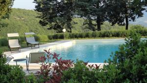 two chairs sitting next to a swimming pool at Agriturismo Vellaneta in Cagli