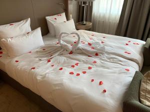 a white bed with red rose petals on it at Townhouse Dresden in Dresden