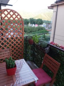 two chairs and a table on a balcony with plants at Casa Giulia Vacanze in Baronissi