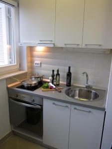 a kitchen with a sink and a stove and a sink at Apartments Klementina in Postira