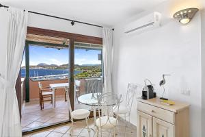 a room with a balcony with a table and chairs at Miramare Flat in Olbia