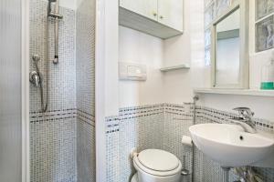 La salle de bains blanche est pourvue de toilettes et d'un lavabo. dans l'établissement Miramare Flat, à Olbia