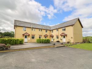 un gran edificio amarillo con entrada en Pheasant Wood, en Llandrindod Wells