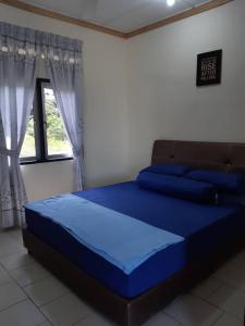 a blue bed in a room with a window at LOT7040 in Melaka
