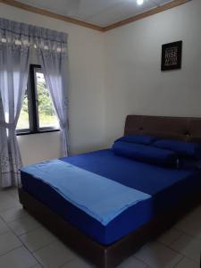 een blauw bed in een kamer met een raam bij LOT7040 in Melaka