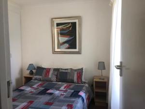 a bedroom with a bed and a picture on the wall at 127 Hermanus Beach Club in Hermanus
