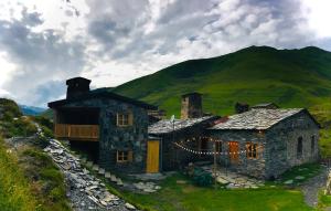 an old stone house with a mountain in the background at Ushguli 12 CENTURY in Ushguli