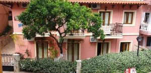 a pink building with a tree in front of it at Elpidas house in Parga