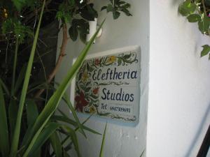 a sign on the side of a wall with plants at Eleftheria Lindian Studios I in Lindos