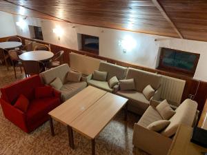 a restaurant with couches and tables and tables and chairs at Penzion Zelené Údolí in Janske Lazne