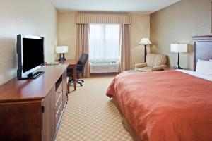 ein Hotelzimmer mit einem Bett und einem Flachbildfernseher in der Unterkunft Travelodge by Wyndham Knoxville West in Knoxville