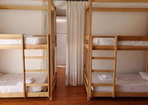 a room with three bunk beds with white sheets at Altíssima Guesthouse Penacova in Penacova