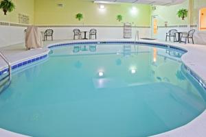 una piscina in una camera d'albergo con sedie e tavoli di Country Inn & Suites by Radisson, Knoxville West, TN a Knoxville