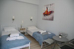 Zimmer mit 2 Betten, einem Tisch und einem Tisch in der Unterkunft Terpsichore Boutique Appartments in Dassia