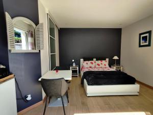 1 dormitorio con 1 cama y 1 mesa con silla en Chez Victoria Nantes Erdre en Nantes